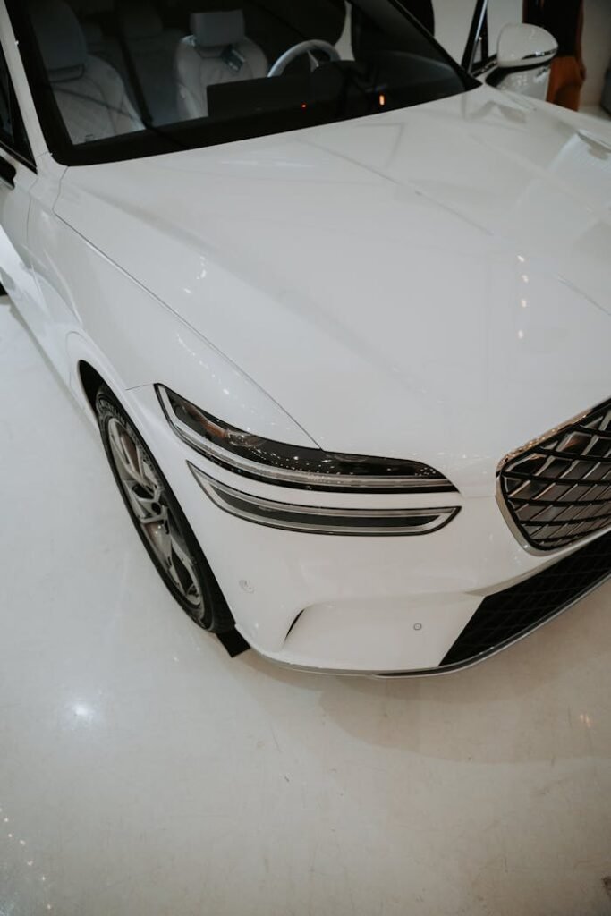 Sleek white luxury car showcased in a modern indoor showroom setting.