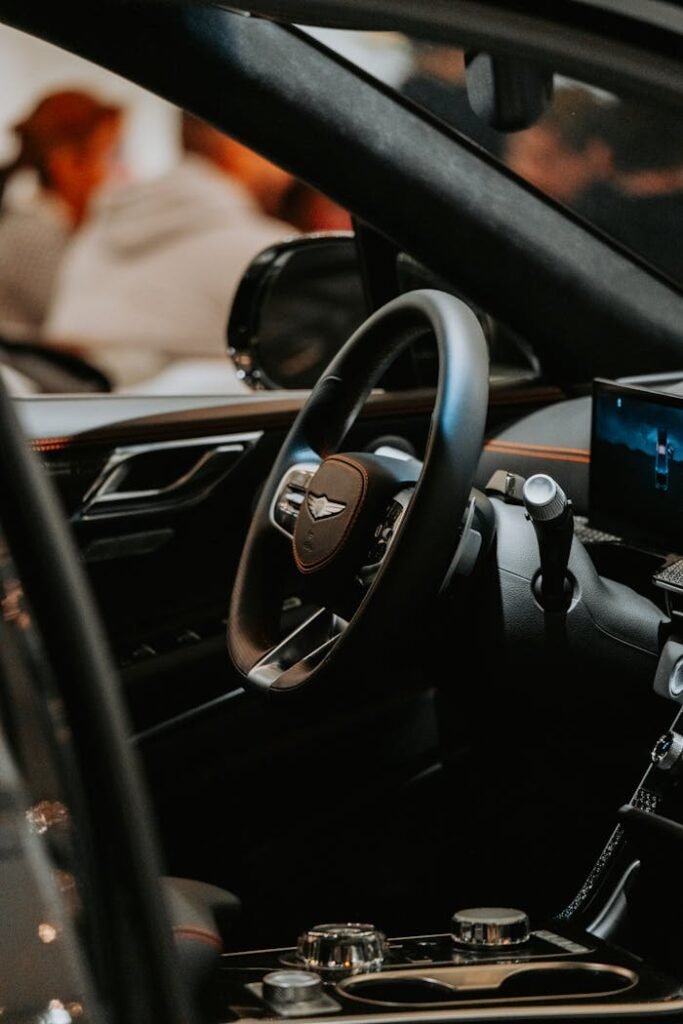 Close-up of luxury car interior focusing on the steering wheel and dashboard.