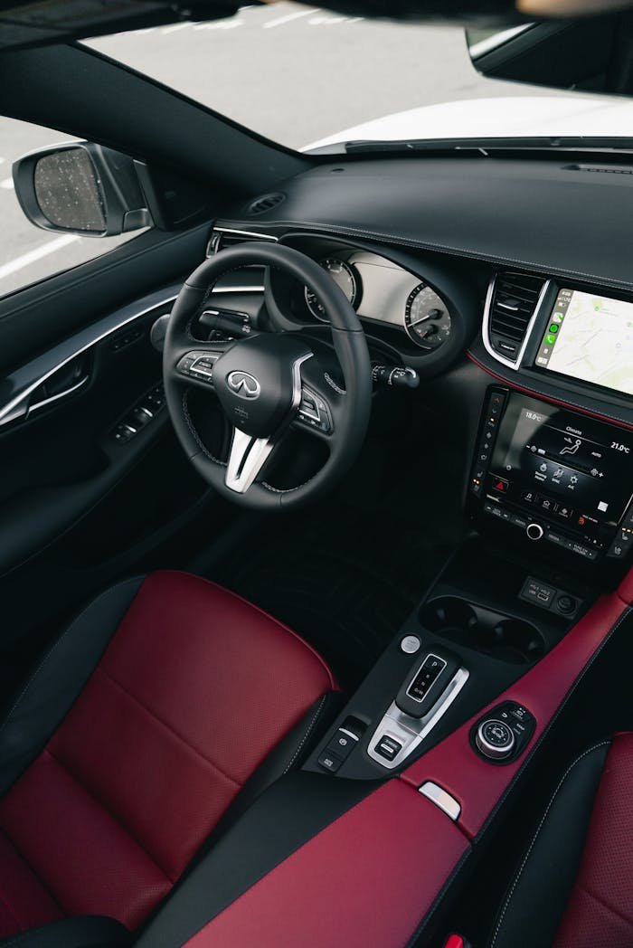 Elegant interior of a luxury car with red leather seats and modern dashboard.